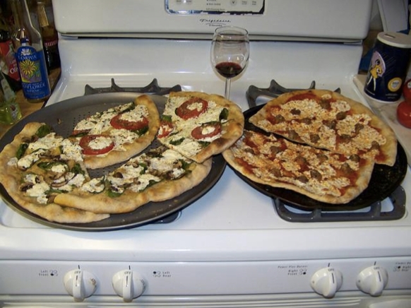 Google: two pizzas sitting on top of a stove top oven