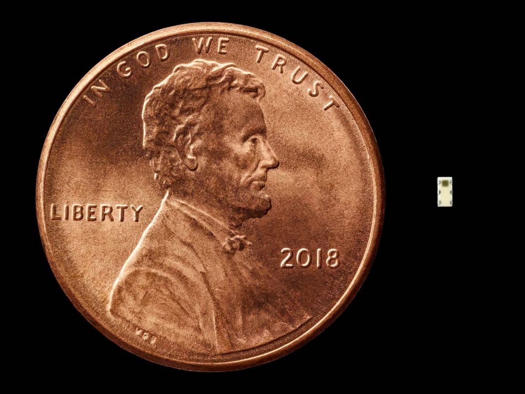 O chip misterioso ao lado de uma moeda de US$ 0,01 (Foto: Bloomberg Businessweek)