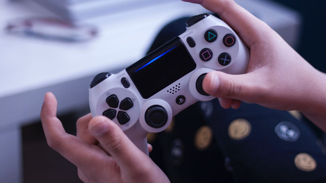 PS4 (ao fundo) e controle DualShock 4 (Imagem: Mélanie THESE/Unsplash)