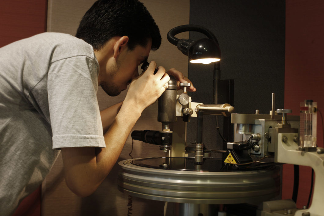 O operador William Carvalho verifica no microscópio a forma do sulco (Imagem: Daryan Dornelles/ Polysom)