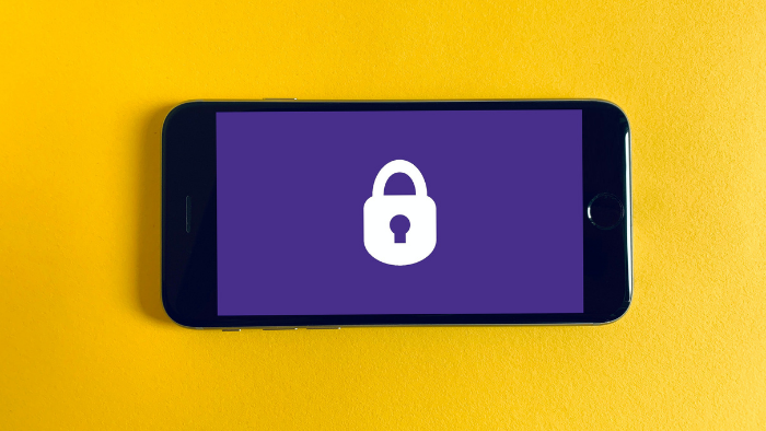 celular com tela roxa e ícone de cadeado em um fundo amarelo