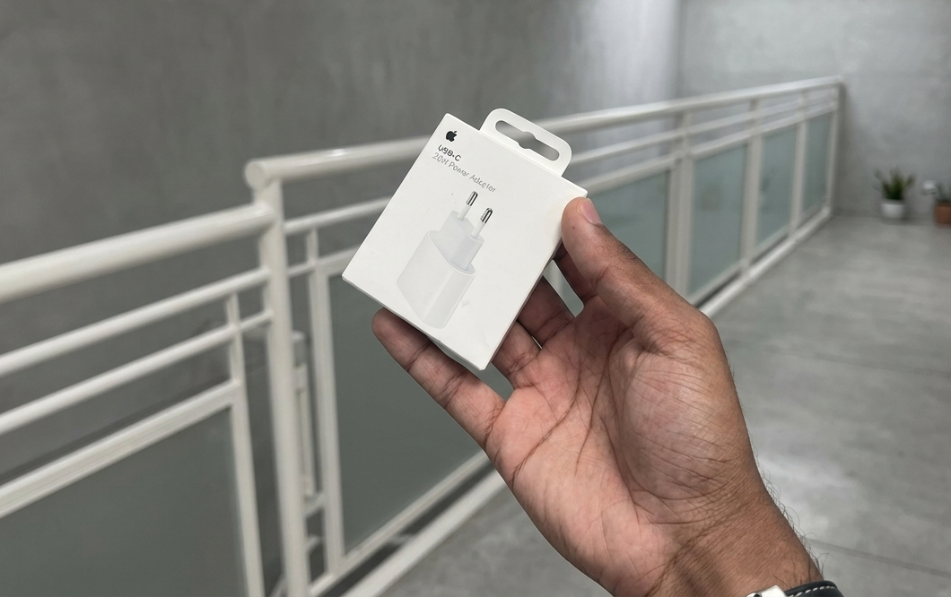 imagem de uma mão segurando a caixa de um carregador de iphone