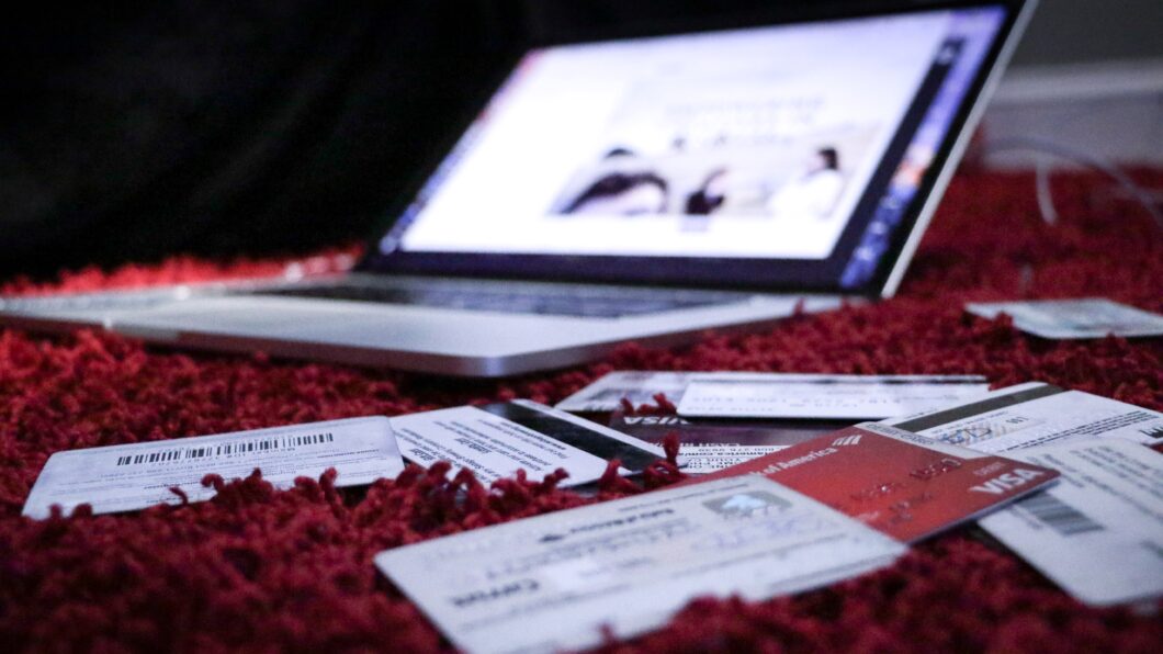 Computador e cartões de crédito. (Imagem: Dylan Gillis/Unsplash)
