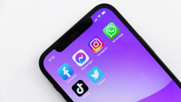 celular em um fundo branco com destaque para os aplicativos de redes sociais