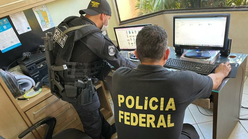 Dois policiais federais usando computador