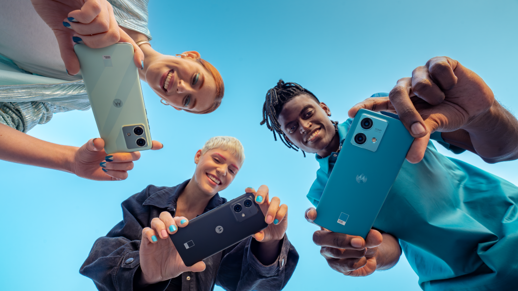 Três pessoas seguram versões preta, verde e azul do Motorola Edge 30 Neo