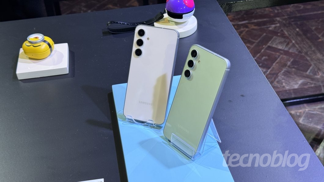 Dois celulares S23 FE, um branco e um verde, em suportes de acrílico transparente