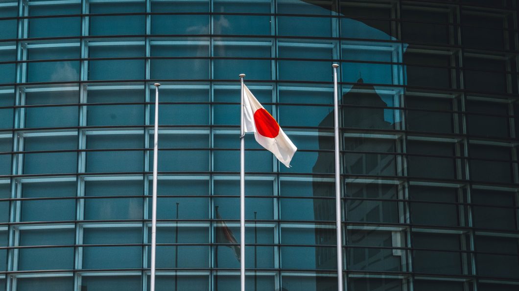 Bandeira do Japão hasteada em frente a um prédio corporativo