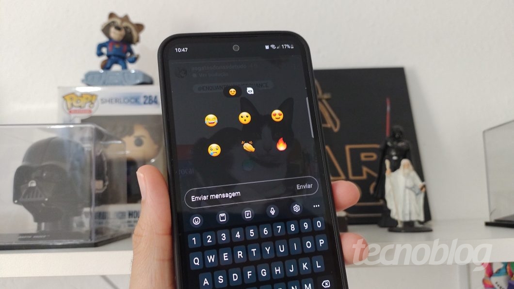 Uma mão segura um celular com o aplicativo do Instagram aberto exibindo os emojis pre-selecionados de reações