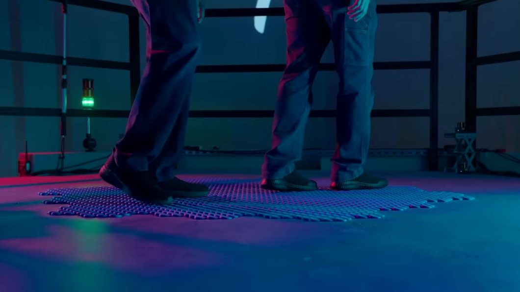 Duas pessoas caminham em cima do piso móvel HoloTide da Disney