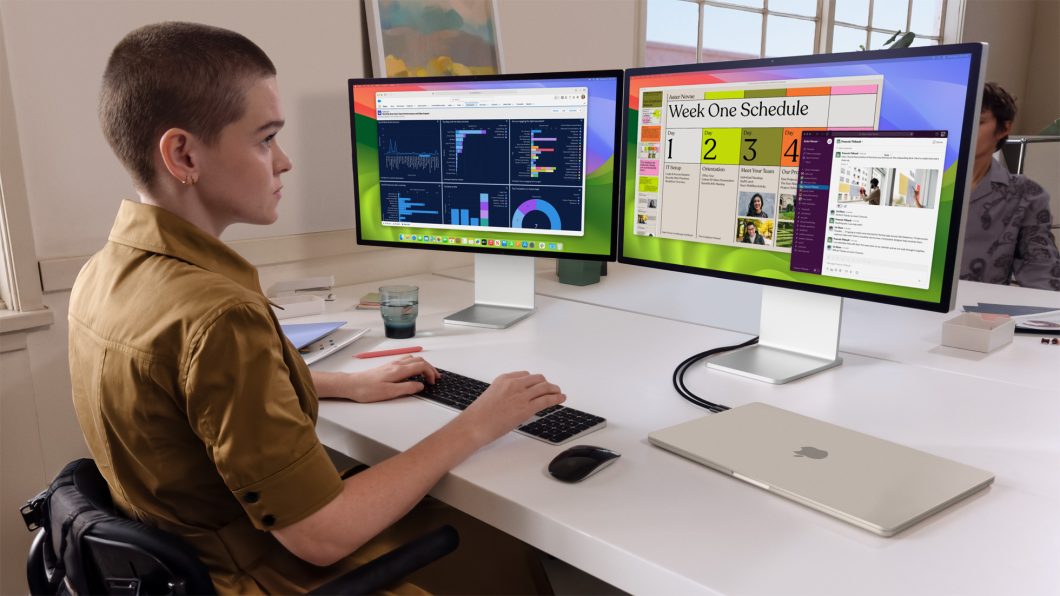 Pessoa usando MacBook Air conectado a dois monitores