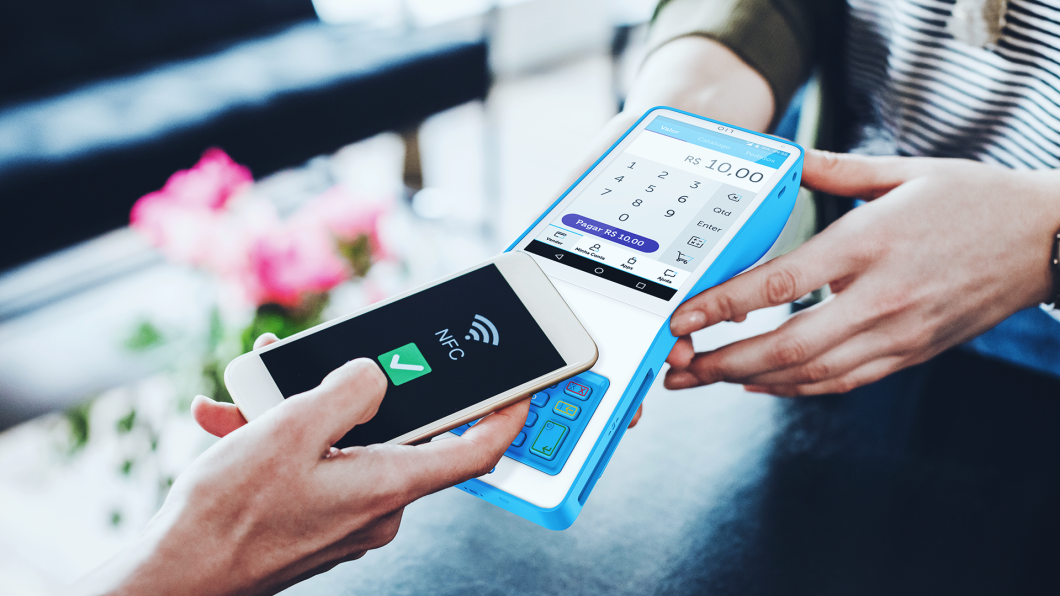 Celular encosta em maquininha para realizar pagamento via NFC