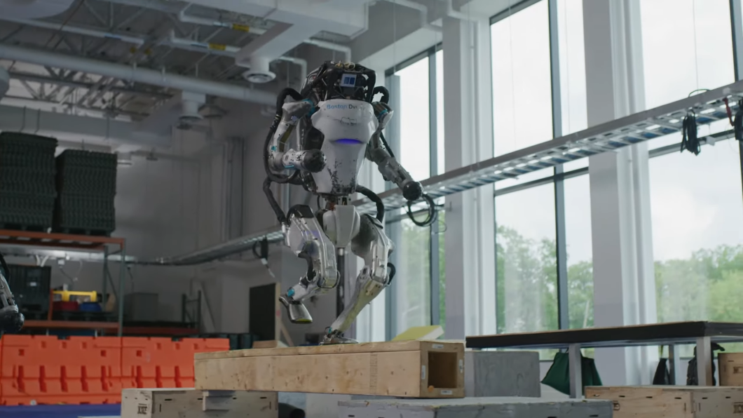 Robô bípede Atlas correndo sobre uma plataforma de madeira