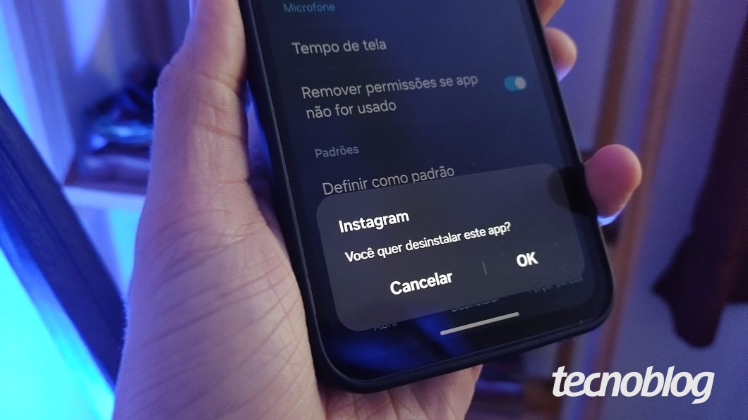 Uma mão segura um celular Samsung que exibe uma tela com a mensagem "Instagram. Você quer desinstalar este app"