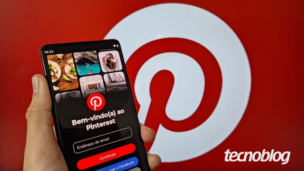 Uma mão segura um celular com o aplicativo Pinterest aberto na tela de login. Ao fundo, o ícone do pinterest