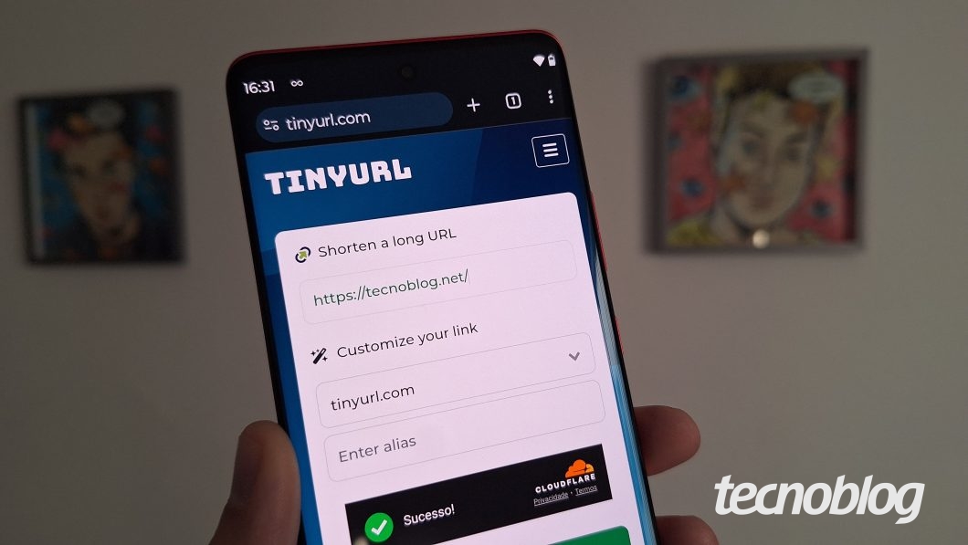 Uma mão segura o celular com a página aberta no encurtador TinyURL