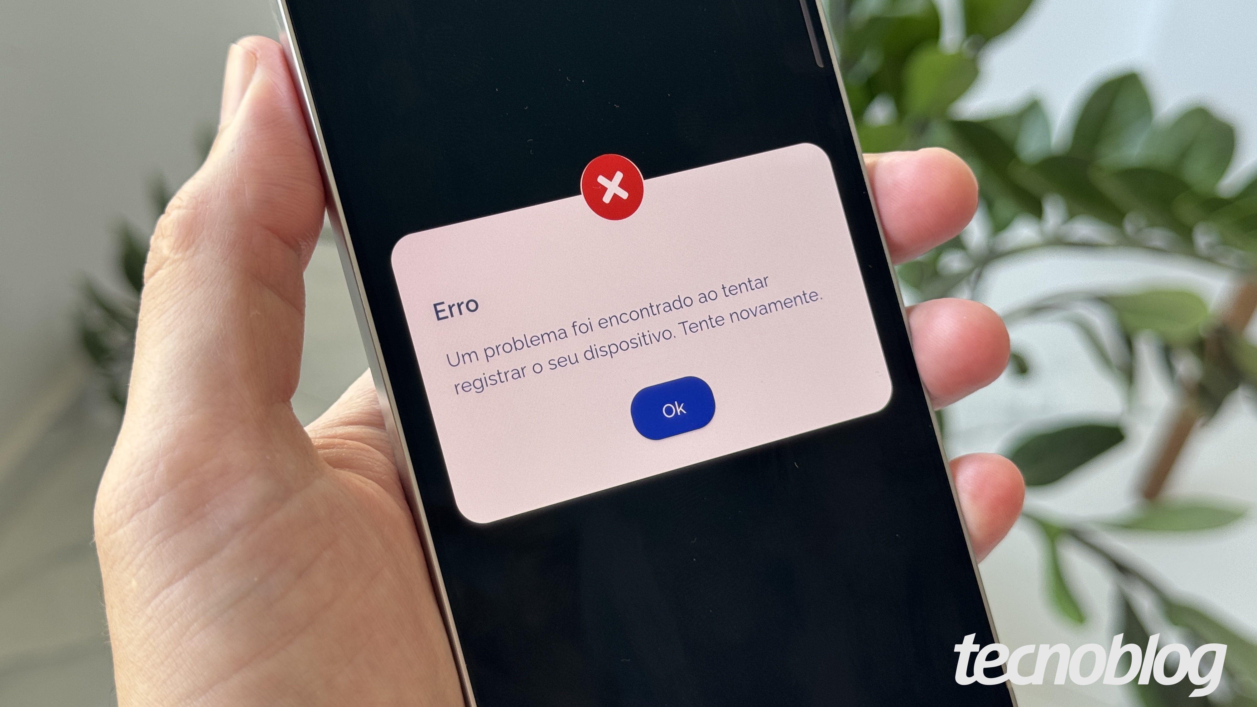 Celular na mão, com erro na tela do aplicativo Gov.br