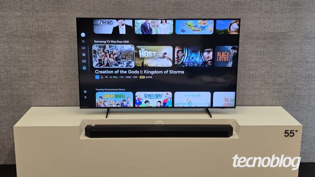 TV de 55 polegadas exibe interface de streaming com títulos e imagens de séries e filmes, som em barra está posicionado abaixo da tela.