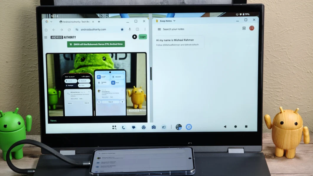 A imagem mostra um monitor com a tela dividida em duas partes: à esquerda, uma página do site "Android Authority" com a interface Android exibindo ícones como "Bluetooth" e "Flashlight", e à direita, o aplicativo Google Keep com uma nota escrita "Hi my name is Mishaal Rahman". Um smartphone conectado ao laptop exibe configurações de pesquisa. Ao lado do monitor, há dois bonecos do Android, um verde e um amarelo.