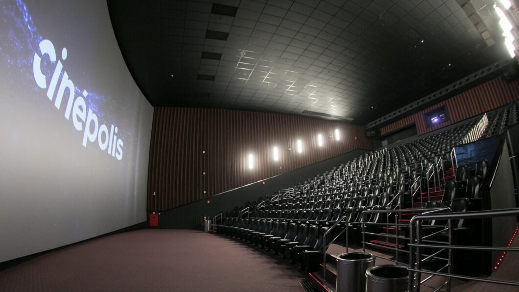 Sala de cinema IMAX da rede Cinépolis, com poltronas vazias e logo da empresa na tela