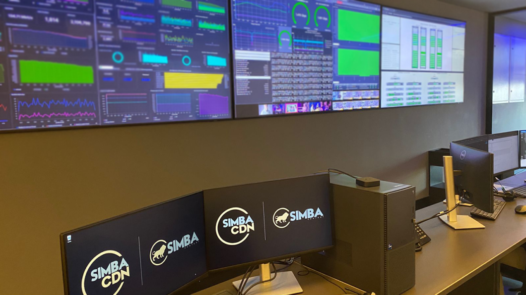 Sala de monitoramento da Simba CDN com telas exibindo gráficos, métricas de rede e painéis de controle em tempo real.
