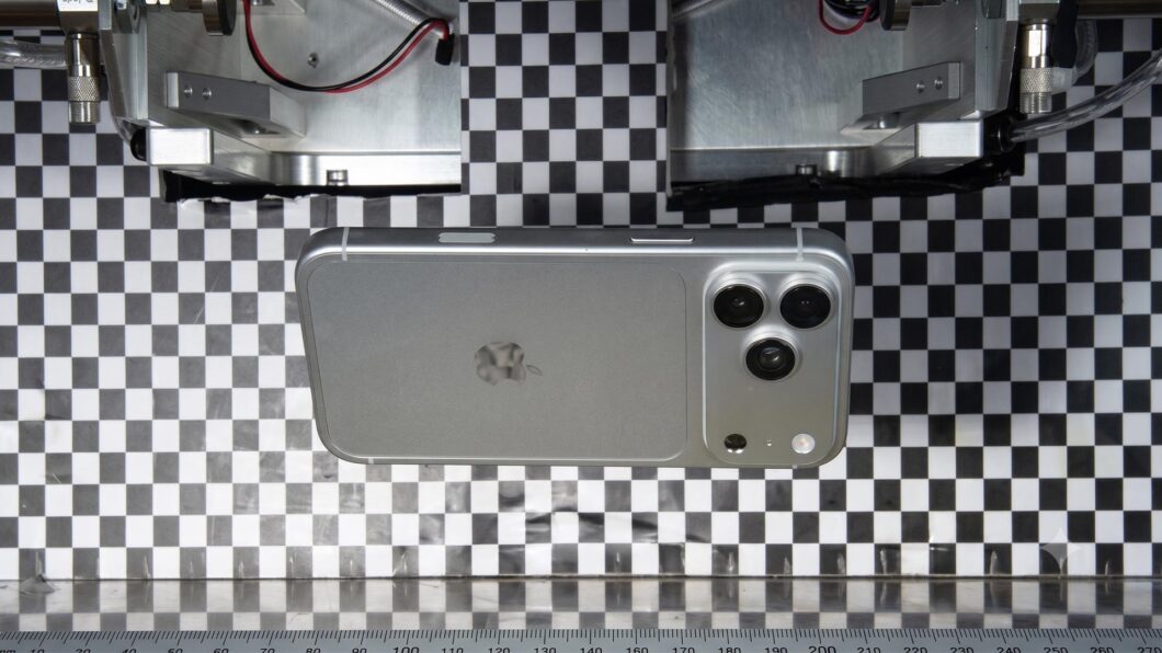 Suposto iPhone 18 Pro em teste de durabilidade, com três câmeras traseiras e flash LED em bancada industrial