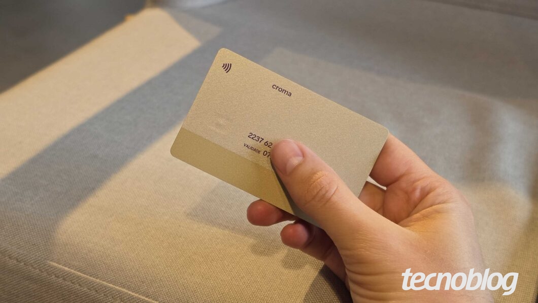 Verso do cartão Nubank Croma na mão, com o logo “croma” e números
