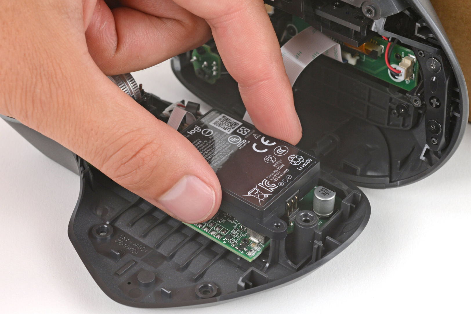 Desmontagem do MX Master 4 com bateria sendo retirada para troca