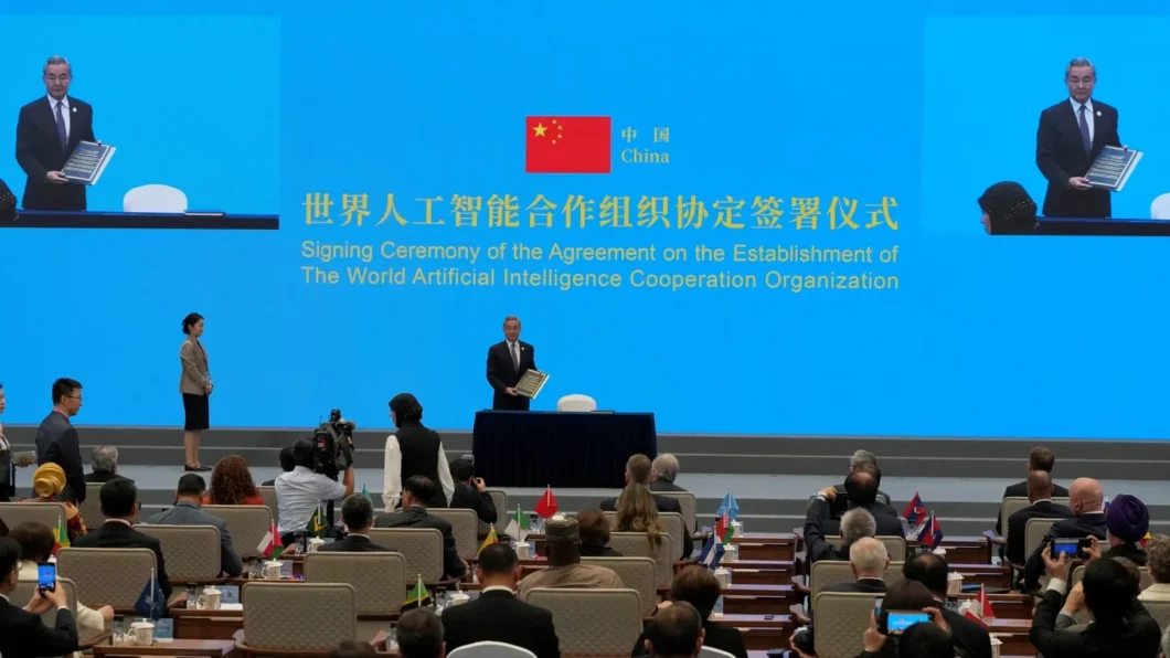 Imagem mostra a cerimônia em Xangai com representantes de vários países. Em destaque, o representante da China, que segura o acordo de IA