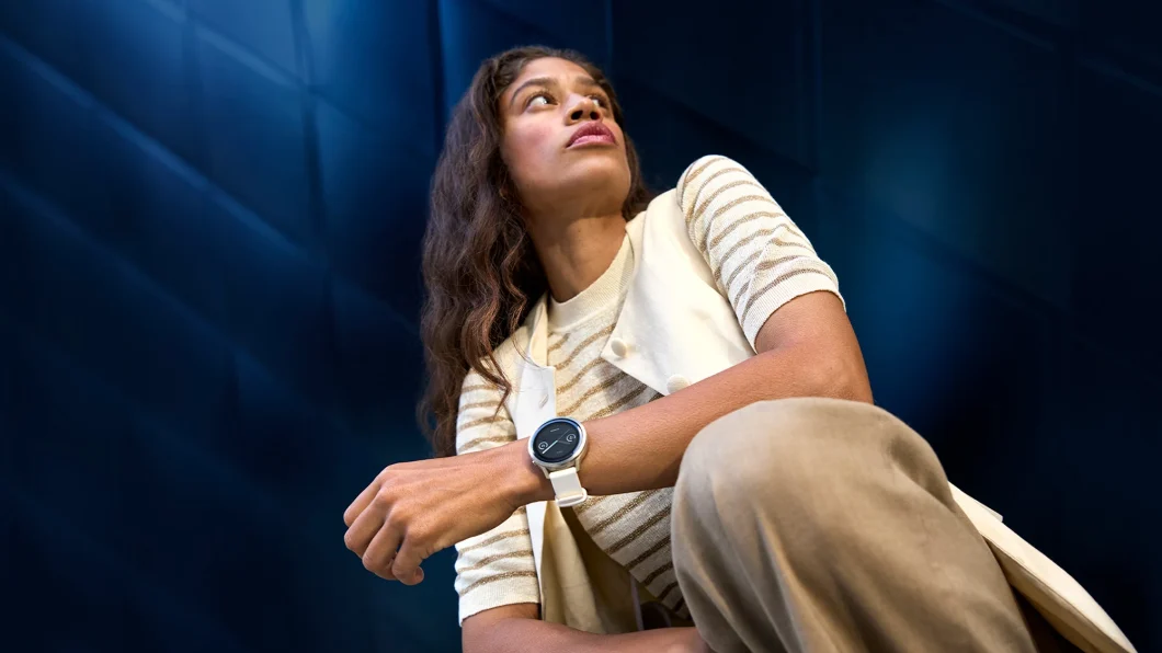 Mulher sentada com um relógio inteligente, olhando para cima em um fundo azul