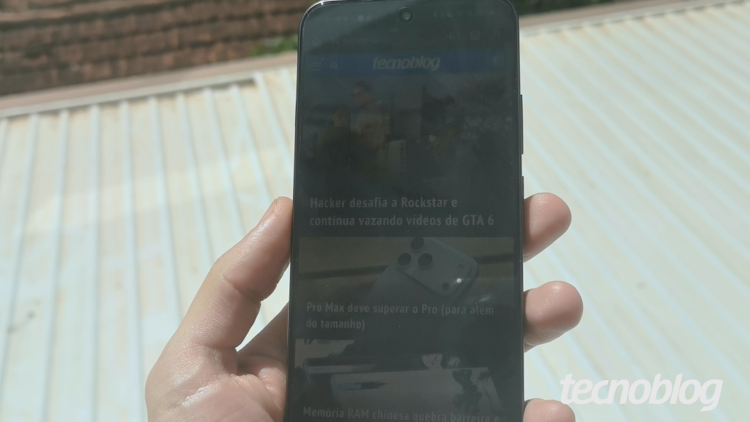 Smartphone Oppo Reno 16 F na mão, exibindo tela de fundo