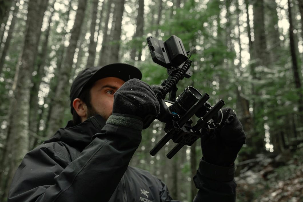 Cinegrafista em ambiente externo, usando a câmera GoPro Mission 1 Pro ILS com lentes intercambiáveis para gravação profissional