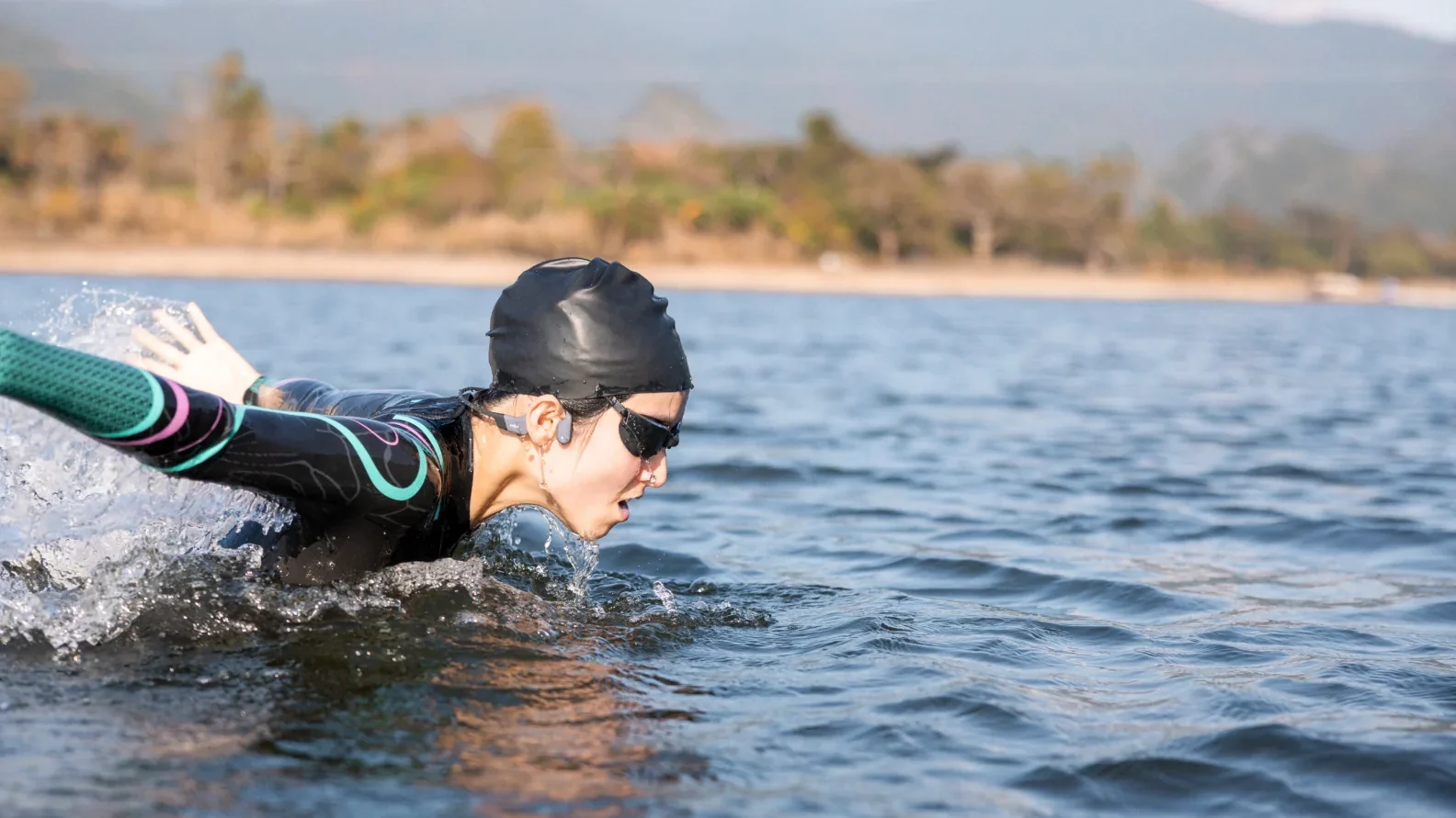 Fone de ouvido Shokz OpenSwim Pro para natação, usado na água durante o treino